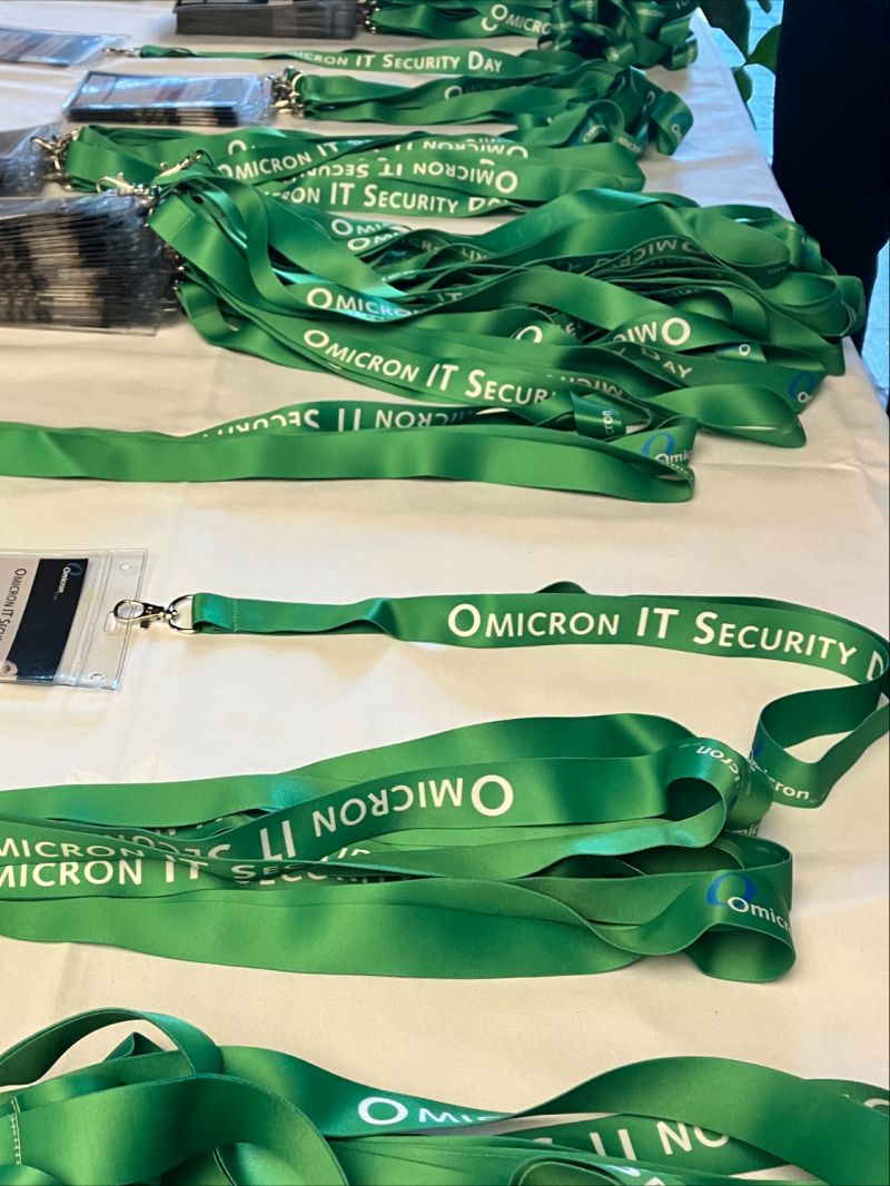 Grüne Lanyards mit „Omicron IT Security Day“-Schriftzug bei einer IT-Sicherheitsveranstaltung