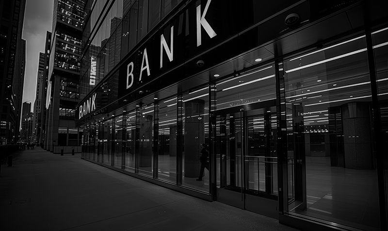 Bankfiliale mit Glasfassade in städtischer Umgebung – Branchenbild IT-Sicherheit im Finanz- und Bankensektor