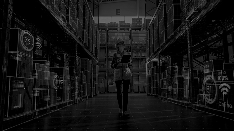 Fachkraft mit Tablet in moderner Lagerhalle mit digital eingeblendeten Netzwerk- und IoT-Daten – Symbol IT-Sicherheit und vernetzte Industrie