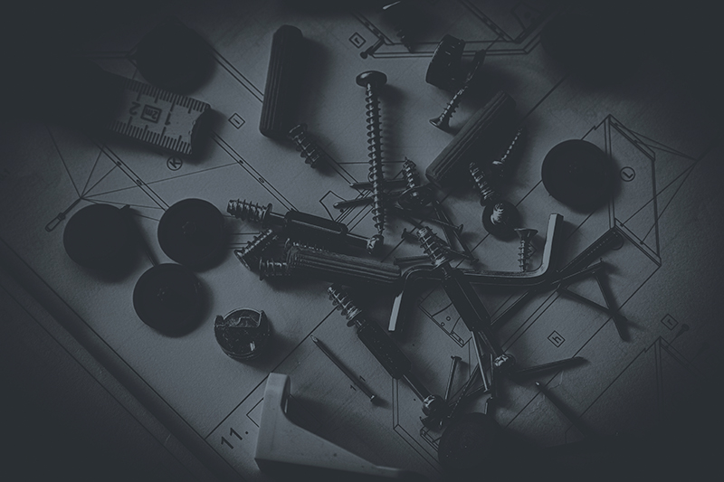 Schrauben und Möbelbeschläge auf Bauplan – Symbolbild für Referenzkunden aus Handel oder Industrie